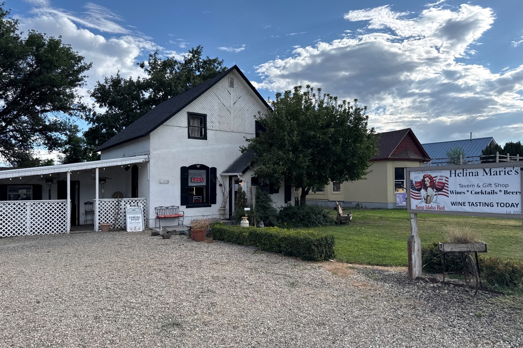 The historic white house on State Street that Helina Marie's calls home, with its covered porch and Helina Marie's roadside sign
